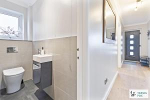 un baño con inodoro y lavabo en Coastal Breeze Retreat, en Swanage 48 fotos más