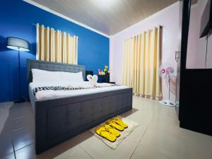 a bedroom with a bed with yellow shoes on the floor at Sukhavati Inn in Baguio