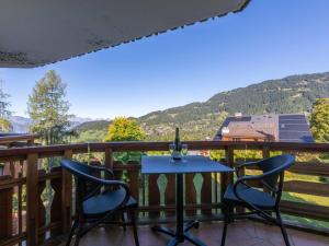 einen Tisch und zwei Stühle auf einem Balkon mit Bergblick in der Unterkunft Studio Le Bristol A25-31 by Interhome in Villars-sur-Ollon