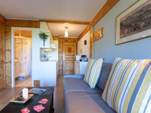 ein Wohnzimmer mit einem blauen Sofa und einem Tisch in der Unterkunft Studio Le Bristol A25-31 by Interhome in Villars-sur-Ollon