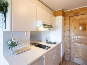 a kitchen with white cabinets and a sink at Studio Le Bristol A25-31 by Interhome in Villars-sur-Ollon