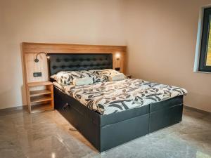 a bedroom with a large bed with a wooden headboard at Holiday Home Party & Friends Villa by Interhome 