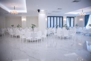 a banquet hall with white tables and chairs and flowers at Hotel Rivera in Dobrich