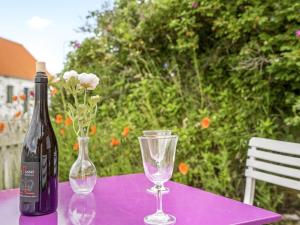 a bottle of wine and a glass on a purple table at Apartment Delfina - 250m from the sea by Interhome in Hjørring +7 photos