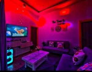 a living room with purple lighting and a tv at the time pool villa พัทยา in Ban Bung