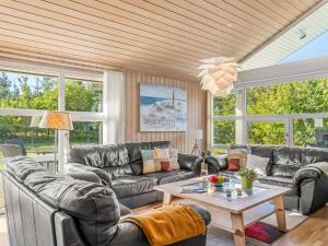 a living room with leather couches and a table at Holiday Home Mechthild - 2-7km from the sea by Interhome in Saltum