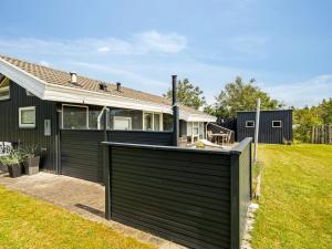 a house with a green fence in front of a yard at Holiday Home Gita - 2-2km from the sea by Interhome in Saltum