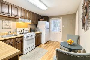 una cocina con armarios de madera y una mesa con un bol de fruta en Oglethorpe Manor Garden Level, en Savannah