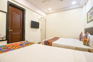 a hotel room with two beds and a television at FabHotel Aksa Inn in Mumbai