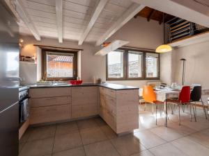 a kitchen with wooden cabinets and a table with chairs at Holiday Home Casa dei Gelsomini by Interhome in Mergozzo +30 photos