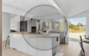 a kitchen with white cabinets and a large window at Lovely Home In Fårvang With Sauna in Roe