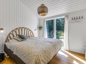 a bedroom with a bed and a large window at Holiday Home Aarthi - 575m from the sea by Interhome in Læsø