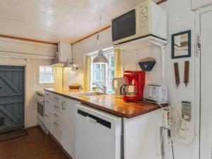 a small kitchen with a sink and a microwave at Holiday Home Thorfrid - 1km from the sea by Interhome in Sønderho