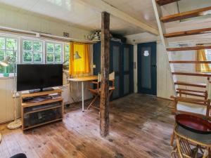 a living room with a flat screen tv and a desk at Holiday Home Thorfrid - 1km from the sea by Interhome in Sønderho