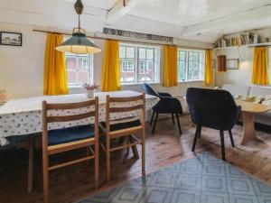 a kitchen and dining room with a table and chairs at Holiday Home Thorfrid - 1km from the sea by Interhome in Sønderho +9 photos