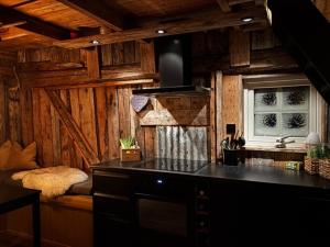 a kitchen with wooden walls and a stove with a window at Serviced Farmhouse - Kvaløyvågen Gård in Kvaløya