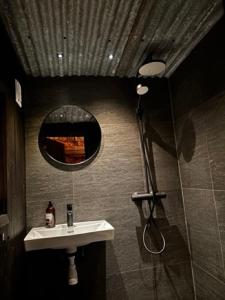 a bathroom with a sink and a mirror and a shower at Serviced Farmhouse - Kvaløyvågen Gård in Kvaløya