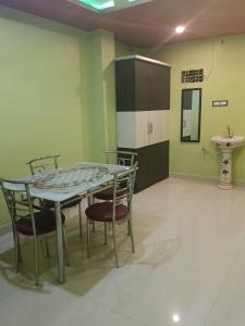 a table and chairs in a room with a sink at Royal plaza Homestay in Daringbadi