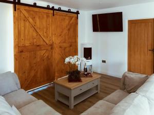 a living room with a wooden sliding barn door at Mac Shack Cottage - Uk32376 in Ashen