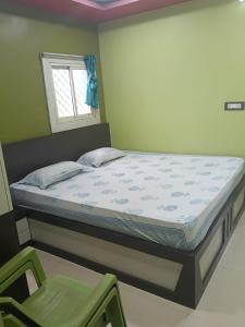 a bedroom with a bed and a chair at Royal plaza Homestay in Daringbadi +25 photos