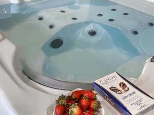 eine Badewanne mit einem Teller Erdbeeren davor in der Unterkunft Barn Owl Cottage- Ukc6985 in Castleside