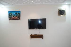 a flat screen tv hanging on a white wall at Yaoundé in Yaoundé