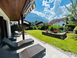 a porch with chairs and a view of a yard at Ferienhaus Alpenperle in Grainau