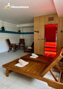 a room with two wooden beds and a red bench at Hotel Prokopávka in Plzeň