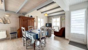 a dining room with a table and chairs at Jolie villa de plain-pied avec jardin et parking in La Couarde-sur-Mer