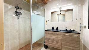 a bathroom with a sink and a glass shower at Jolie villa de plain-pied avec jardin et parking in La Couarde-sur-Mer +3 photos