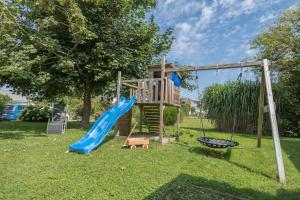 a playground with a slide and a swing at Gästehaus Heinemann - Og1 in Langenargen