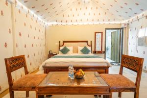a bedroom with a bed and a table and chairs at Happy Adventure Camp & Resort Sam Jaisalmer in Sām