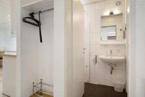 a white bathroom with a sink and a mirror at Gästehaus Heinemann - Og1 in Langenargen +23 photos