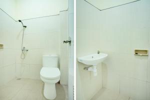 a white bathroom with a toilet and a sink at Hotel O Palembang near Palembang City Center Mall formerly Kostel 97 in Palembang