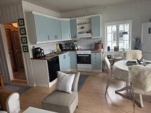 a kitchen with blue cabinets and a table and a table and chairs at The Vrådal Pearl in Vradal