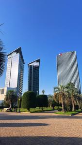 three tall buildings in a park with palm trees at Apartment with sea View in Batumi