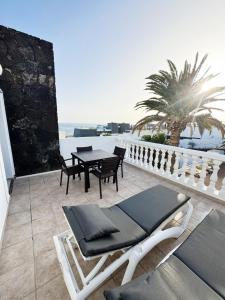 a patio with a table and chairs on a balcony at B17 Caleton blanco in Tías
