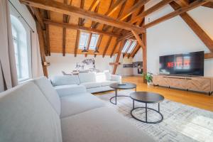 a living room with a couch and a tv at LUXOMES - Tropical & Streetart Style - Old Town Apartments - Central Ingolstadt in Ingolstadt