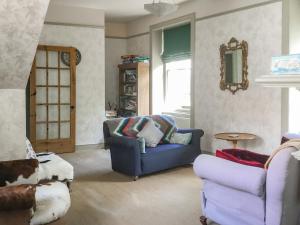 a living room with a blue couch and a chair at Campbells Stables in Berwick-Upon-Tweed