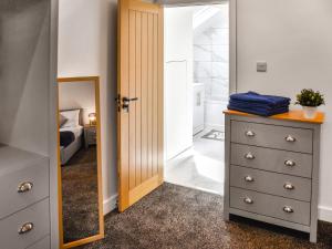 - une chambre avec un placard et une commode avec un miroir dans l'établissement Faith Cottage, à Little Dunham