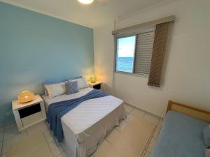 une petite chambre avec un lit et une fenêtre dans l'établissement Vista deslumbrante e elegância frente mar!, à Vila Balneária