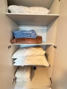un placard avec des serviettes et des oreillers dedans dans l'établissement Vista deslumbrante e elegância frente mar!, à Vila Balneária