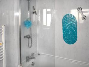 a bathroom with a shower and a bath tub at Mariners Cottage in Dawlish +2 photos