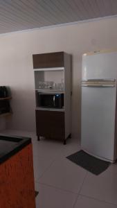 a kitchen with a white refrigerator and a stove at Apartamento Tucano in Alto Paraíso de Goiás +6 photos