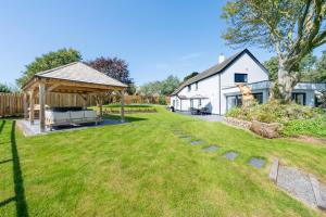 a backyard with a gazebo and a house at 4 Bed in Woolfardisworthy oc-s32421 in Woolfardisworthy