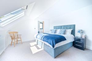 a bedroom with a blue bed and a chair at 4 Bed in Woolfardisworthy oc-s32421 in Woolfardisworthy +47 photos