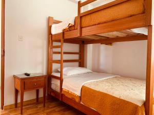 sypialnia z dwoma łóżkami piętrowymi i stołem w obiekcie Hotel Silver w mieście Tacna