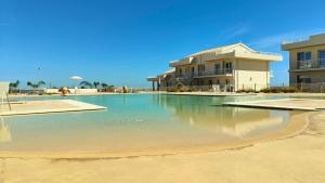 una piscina di fronte a un edificio di Olimpia Holiday con Piscina fronte mare a Marzamemi