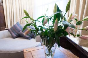um vaso de flores numa mesa numa sala de estar em The Pearl Hotel em Peterborough