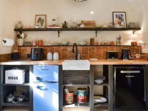 a kitchen with a counter with a refrigerator and a sink at Clematis - Uk50451 in Ruswarp +15 photos